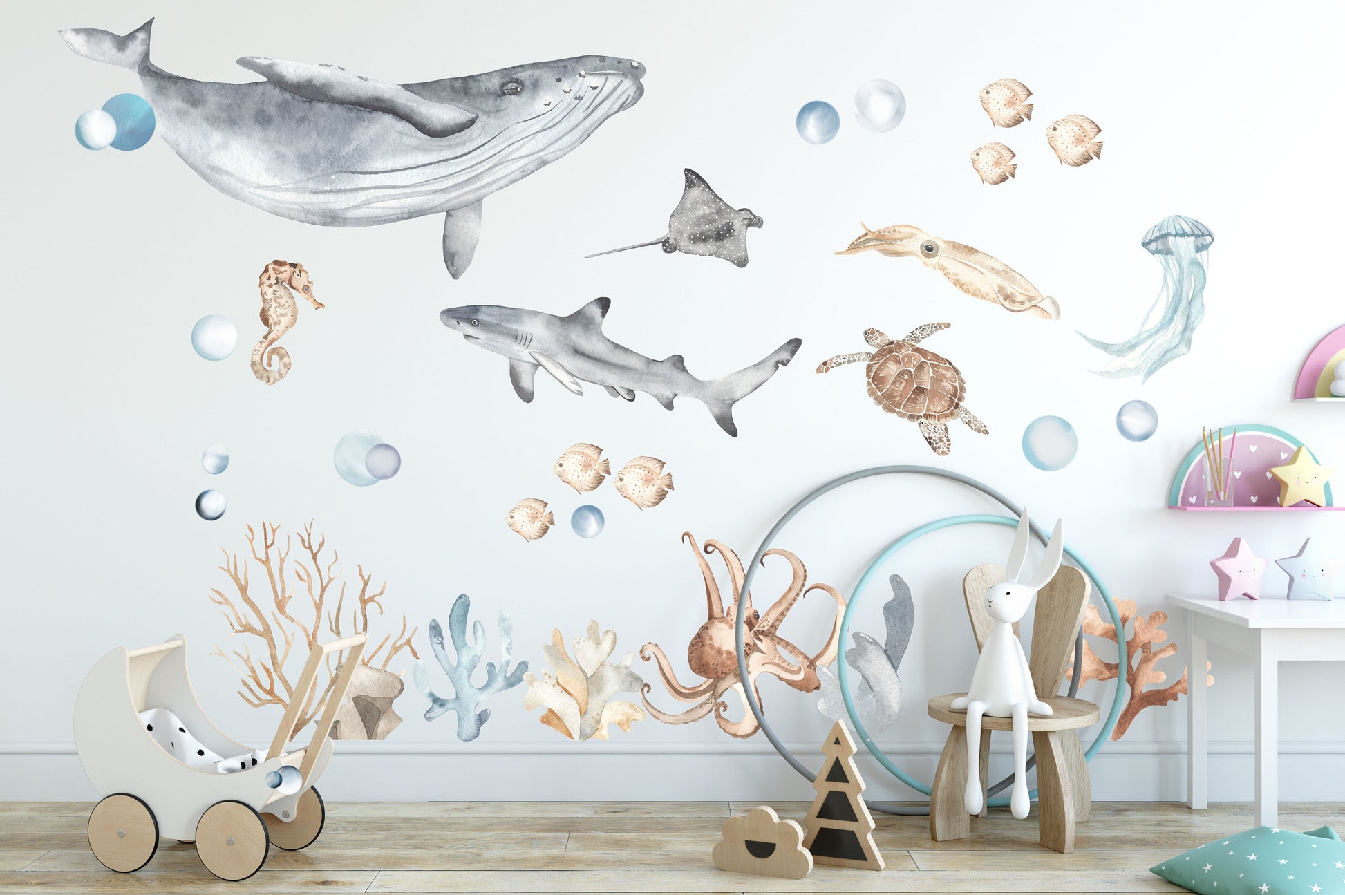 Kids' room with underwater ocean wall decals illustrating a whale, shark, stingray, jellyfish, turtle, octopus, coral, and bubbles, creating a dreamy marine environment.