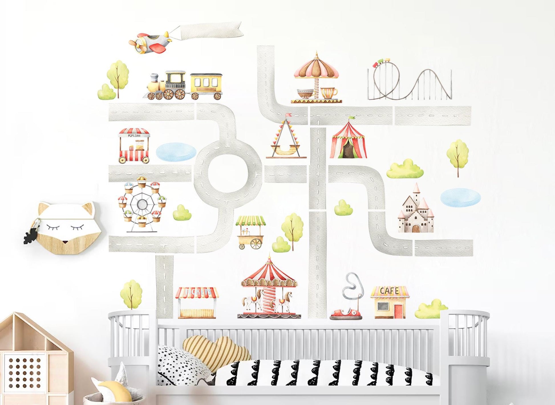 Nursery room wall decorated with colorful amusement park decals, including carnival rides, circus tents, ferris wheel, roller coaster, and playful road design.